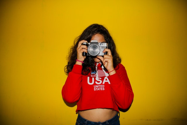 photo-of-a-women-wearing-a-red-crop-top-holding-camera-2566238