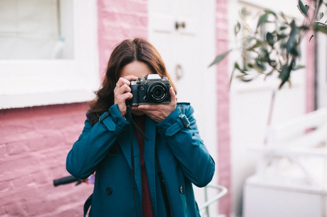 photo-of-woman-using-black-dslr-camera-1579617